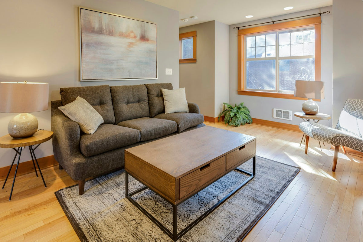 Three-seat sofa, coffee table and accent chair sharing a modest living room.