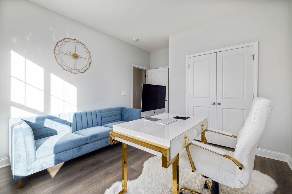 Light-blue sofa opposite a white desk and office chair in a bright home office.