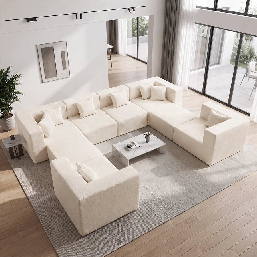 Cream U-shaped modular sofa arranged around a central coffee table with an open entry