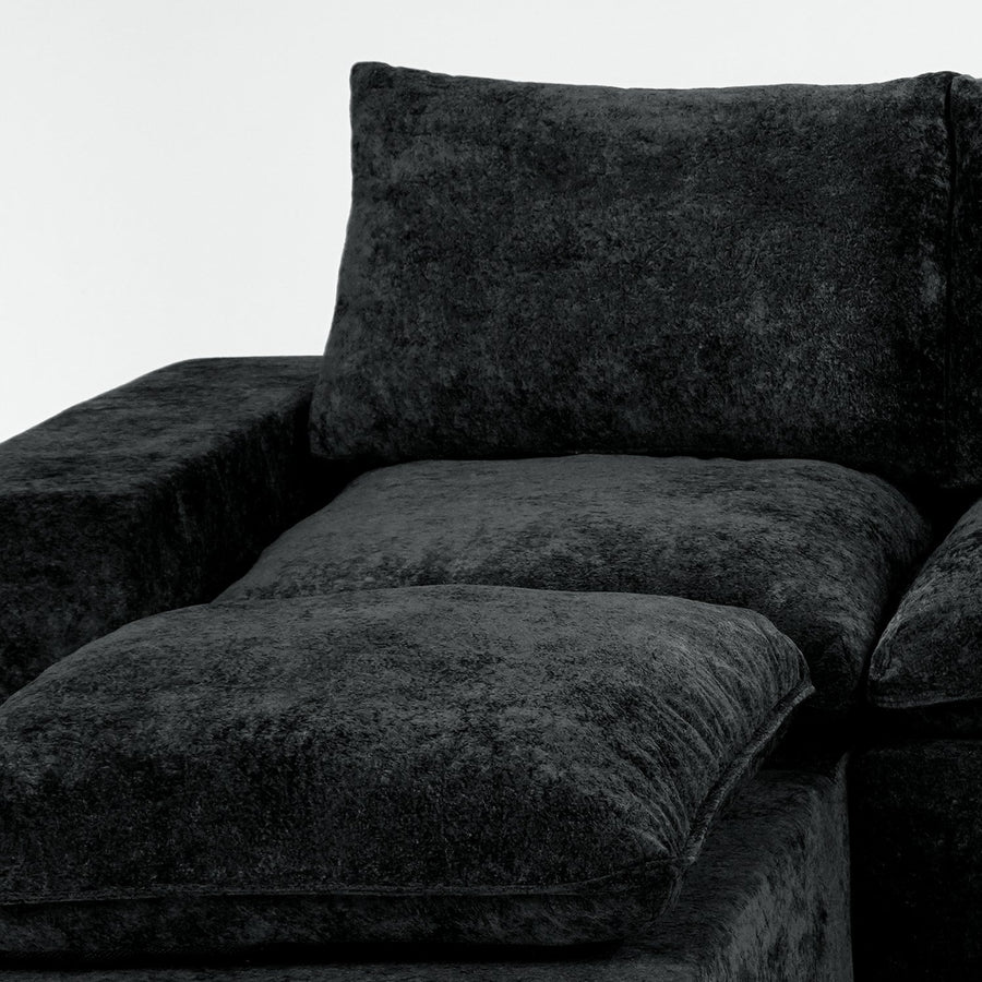 Close view of a dark modular sofa showing the seam between a seat and forward module