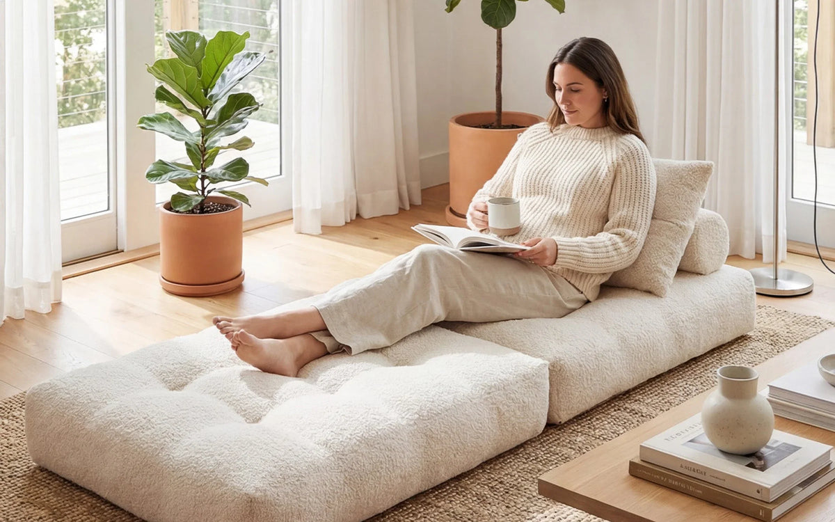 Adult reading on a beige Monvane Oversized Sofa Bed extended in a low lounger state.