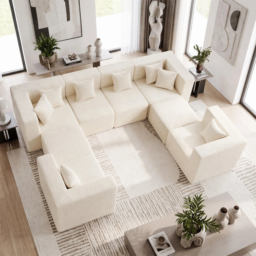 Beige Monvane modular U-shaped sofa with matching square pillows placed at several corners.