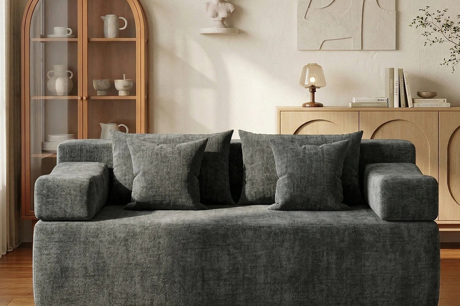 Gray Monvane chenille loveseat with several loose square pillows and visible pillow seams.