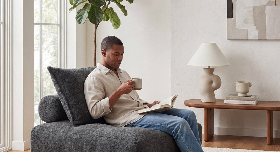 A person reading while seated on a dark gray Monvane Oversized Sofa Bed.