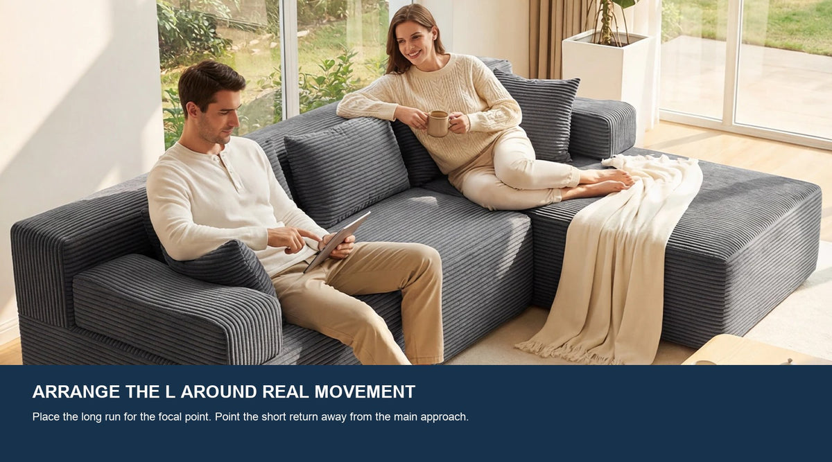 A couple using a gray Monvane L-shaped sectional in a bright living room with an open approach.