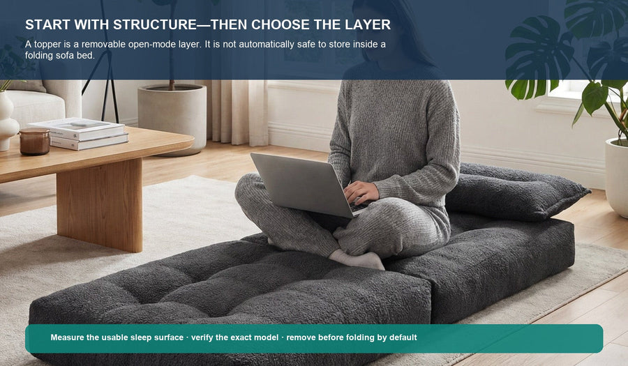 A woman using a dark gray Monvane Oversized Sofa Bed in its flat open state.