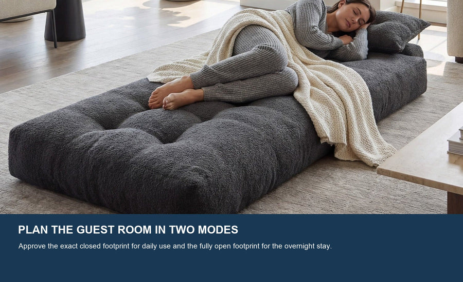 One adult resting on a dark gray Monvane Oversized Sofa Bed opened flat in a bright room.