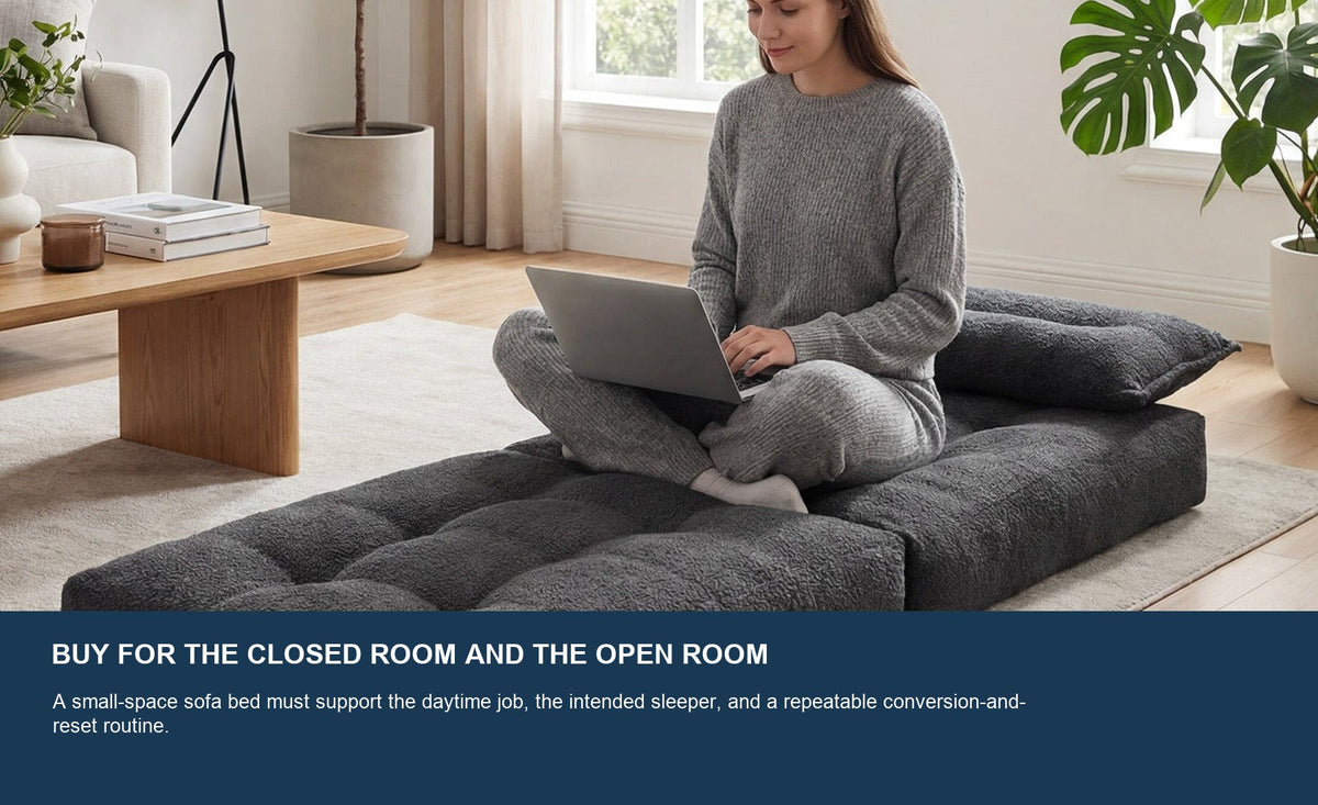 One adult using a dark gray Monvane Oversized Sofa Bed opened flat in a bright, compact living area.